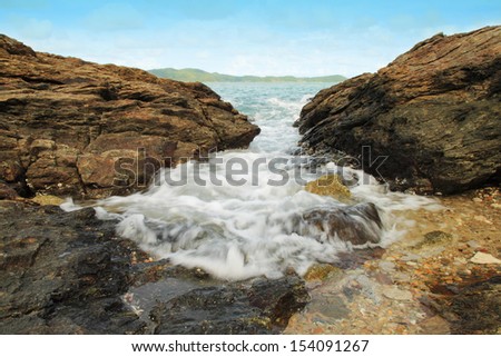 Sea waves hitting round rocks and splashing