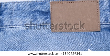 Blank leather jeans label sewed on a blue jeans.


