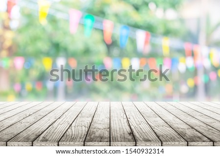 Empty wooden table with birhday party in garden background blurred.
