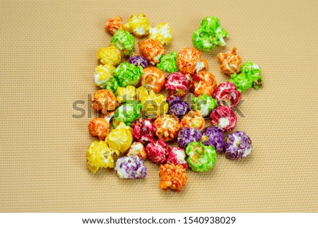 delicious colored popcorn isolated on yellow background