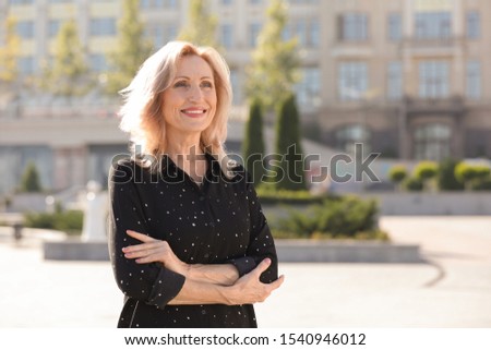 Portrait of happy mature woman on city street