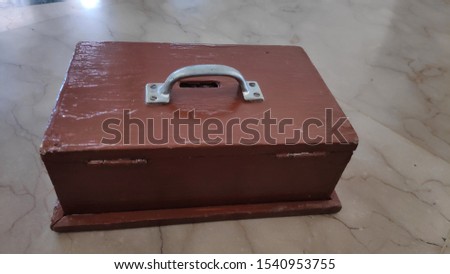 A wooden charity box, to put money in, is placed on the mosque floor