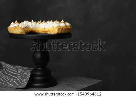 Stand with delicious lemon meringue pie on grey table, space for text