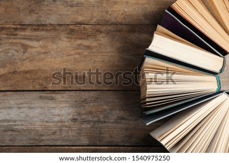 Hardcover books on wooden background, flat lay