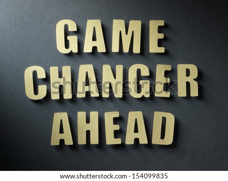 The word Game Changer Ahead in cut out paper letters on paper background