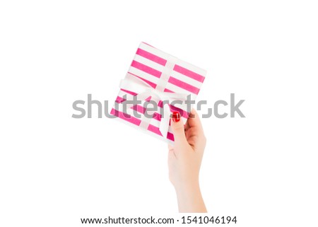 Woman hands give wrapped Christmas or other holiday handmade present in pink paper with white ribbon. Isolated on white background, top view. thanksgiving Gift box concept.