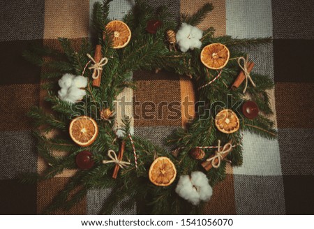 Green fir tree wreath for front door decoration on 2019 New Year.Beautiful handmade home decor elements for Christmas Eve.Dry oranges,cinnamon sticks and evergreen branches in close up