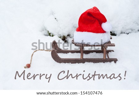 christmas card with sledge and santa hat/Merry Christmas/english
