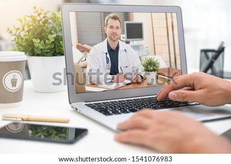 Doctor with a stethoscope on the computer laptop screen. Telemedicine or telehealth concept. Royalty-Free Stock Photo #1541076983