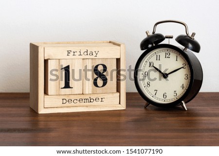 Wood calendar with date and old clock. Friday 18 December