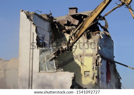 Demolished old soviet union building remains with orange bulldozer