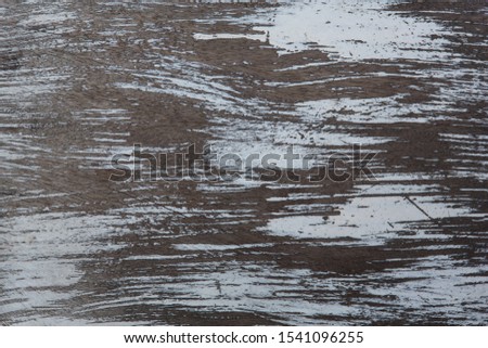 grunge filled frame close up background wallpaper shot of a brown wooden wall plank surface with chipping and peeling white paint forming beautiful patterns and shapes