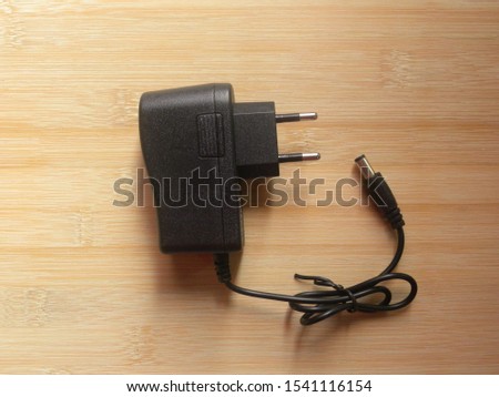 Black color 2 pin power plug adapter kept on wooden table