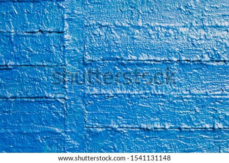 The old wooden surface is painted with blue oil paint. Close-up. Texture. Abstract background