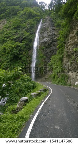beautifull waterfall flowing through road and mountain..