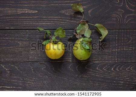 Fresh organic yellow apple and green pear in the center on a natural brown wooden background