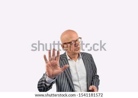 Bald adult man with glasses in a striped jacket making the gesture stop here go no further