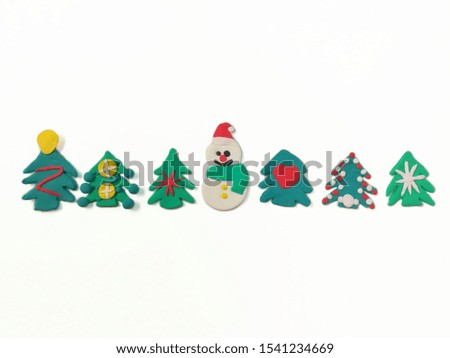 Cute snowman have sweet smile, colorful ornaments on Christmas tree are made from plasticine clay are placed on white background, beautiful dough decorate are festival