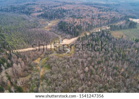 Aerial view with a drone. Landscape with autumn forest and dirt road.