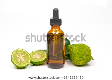 Bergamot oil in bottle and fresh bergamot fruit with green leaf isolated on white background.