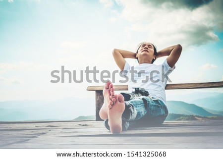 Blur images of Asian male photographer Sitting and resting on a wooden balcony And relax with the beautiful nature, fresh air, with mountain range background to people and vacation concept