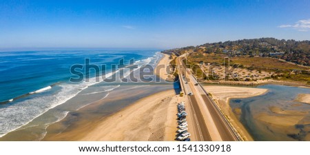 Beautiful aerial view of the San Diego coastline with amazing golden beaches, docks and the town itself by the Pacific ocean.