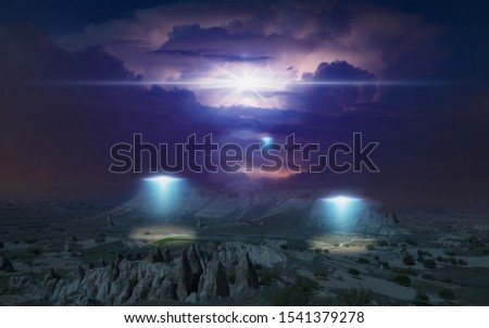 Dark dramatic sci-fi image: alien ships inspect planet's surface with bright spotlights in dark night sky, thunderclouds are illuminated by lightning from inside in background.