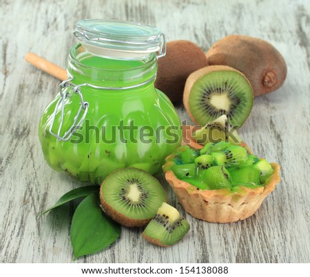 Jar of jam kiwi on wooden table close-up