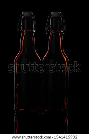 two glass beer bottles on a black background