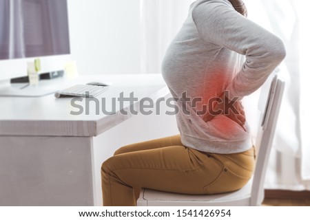 Kidney pain. Sick back in a woman from sedentary work.  Royalty-Free Stock Photo #1541426954