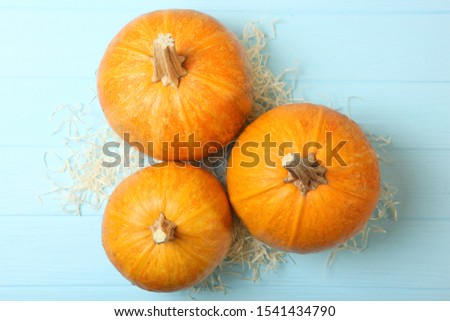 Autumn background with leaves and pumpkins on a colored background top view. Thanksgiving concept.
