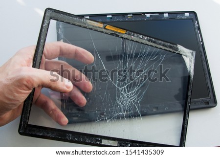 Cracked tablet computer with broken glass touch screen. A technician is fixing and replacing the broken screen on damaged gadget. Repair device in service center.