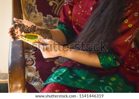 Closeup shot of hand of an Indian female holding diya on Diwali Festival.