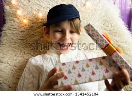 A 10-year-old European boy receives and enjoys a Christmas present.