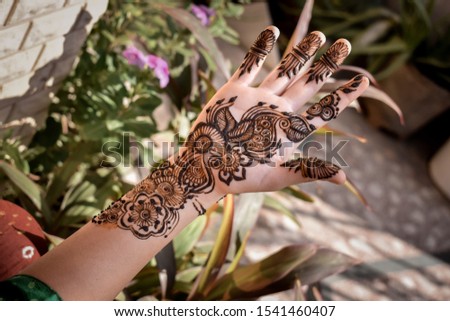 Close up shot of Indian female hand with mehndi design on diwali festival.