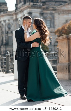 Concept about love,relationship, and travel. Photo of a lovely couple having fun while traveling in their vacation time. Lady in a green dress. Man in suit. Stylish loving couple pose. Tenderness 