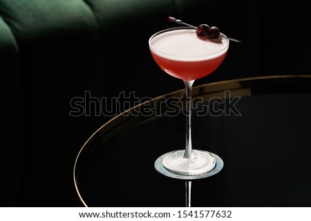 Fresh cocktail glass on glass table in night club restaurant. Alcohol cocktail drink, close-up. Retro alcoholic beverage Royalty-Free Stock Photo #1541577632