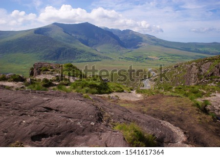 A view of the post-glacial Owenmore Valley on the Dingle Peninsula, Co. Kerry, Ireland, as seen from the Conor Pass mountain drive. Royalty-Free Stock Photo #1541617364