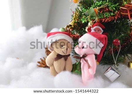 Teddy bear standing in front of soft and blurred focus the Christmas tree.