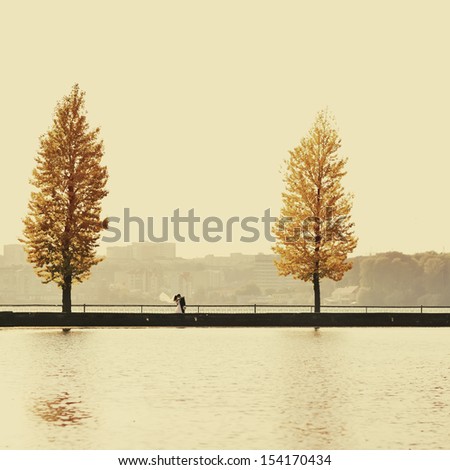 newly wed couple standing on a bridge, autumn picture