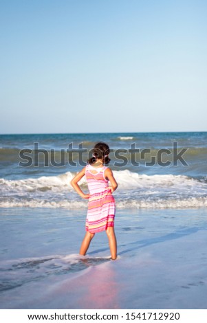A girl frolicking in the ocean on the beach.