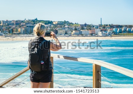 Traveler woman using smartphone take photo landscape view of Bondi beach at sydney city, Australia.