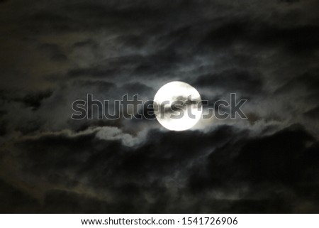 Gray clouds were moving across the moon's scary ghosts.