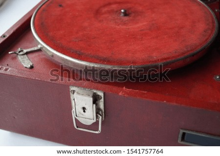 old red gramophone with vinyl record on white background