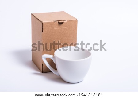 White porcelain cup and brown craft cardboard box, isolates mock