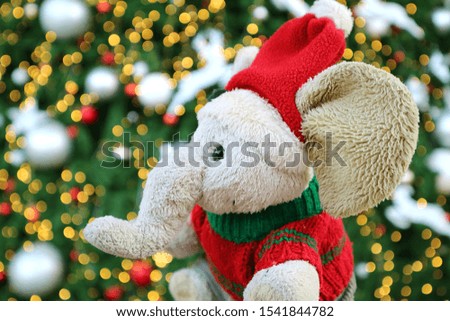 Adorable Elephant doll with Santa Hat in front of Glittering Christmas Tree