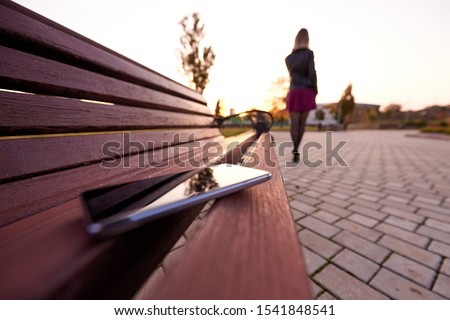 Forgotten smartphone on a park bench. Royalty-Free Stock Photo #1541848541