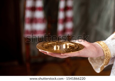 Gold wedding rings on the gold plate in the church