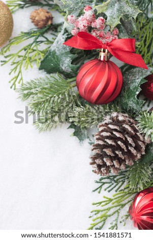 Christmas background with balls, baubles and green fir branches, pine cones, on white snow background. Winter holidays. Christmas abstract greeting card. Copy space for text.