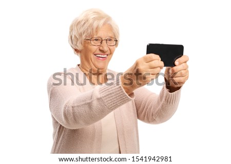 Elderly woman taking a photo with a mobile phone isolated on white background
